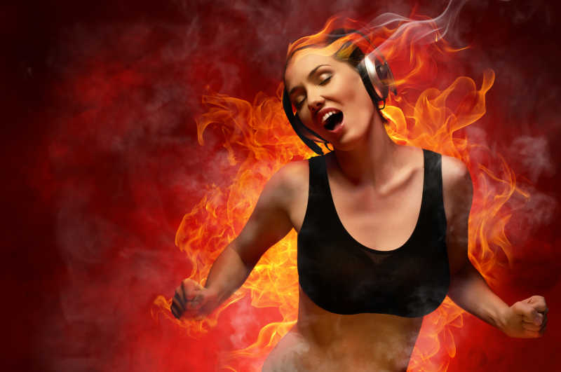 火焰背景下戴着耳机的美女