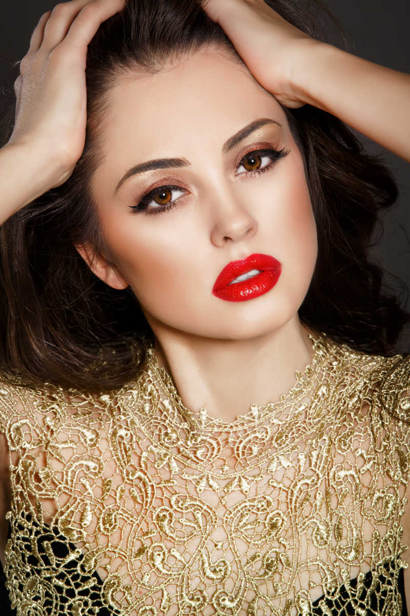 双手抱头的红唇美女