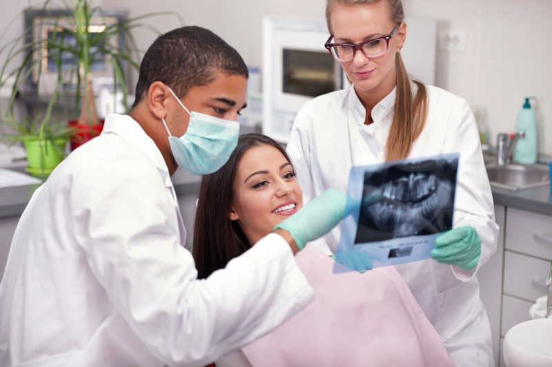 牙科医生与患者看透视X光图像
