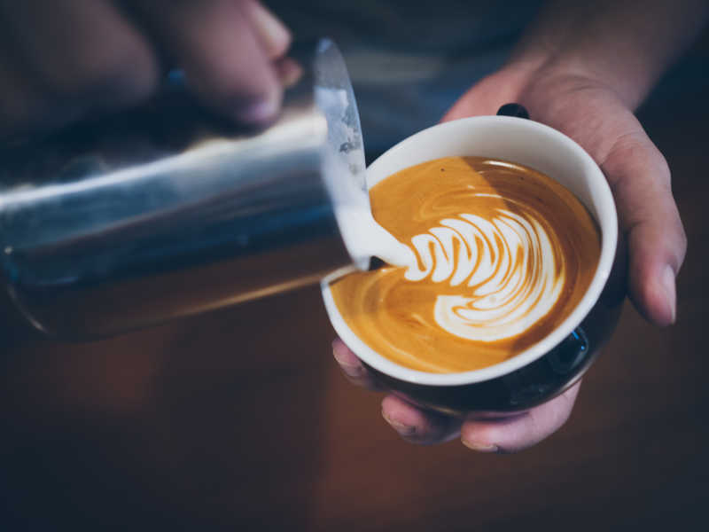 用瓷碗制作拿铁咖啡的瞬间摄影