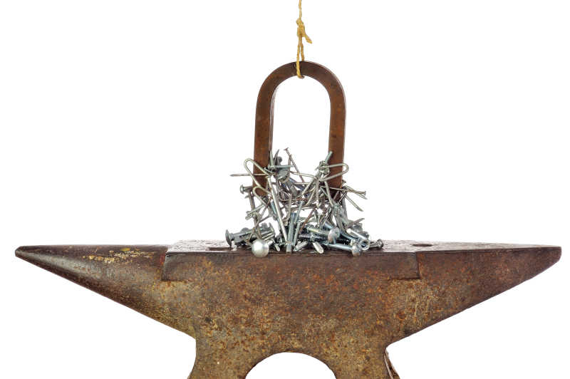 白色背景下吸引着铁器的马蹄形磁铁