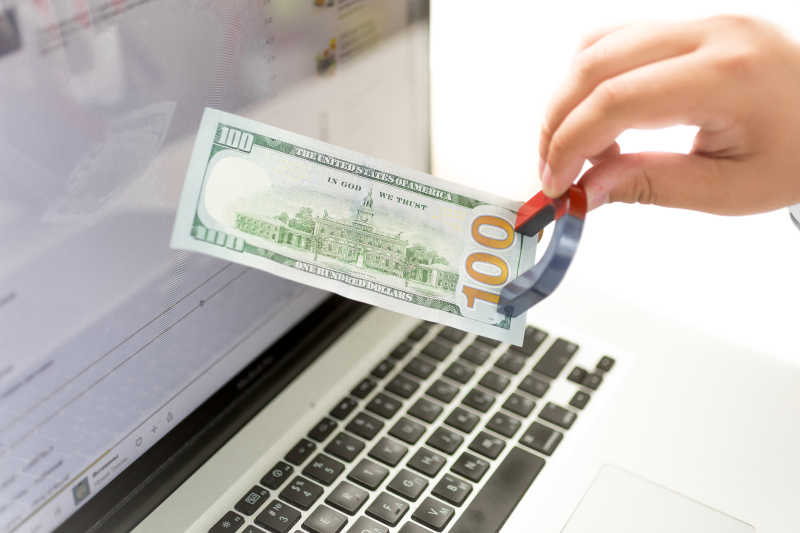 笔记本电脑前吸住纸币的磁铁