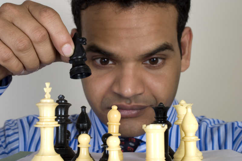 男子手持黑色棋子