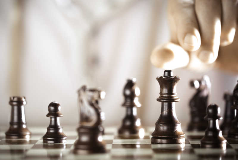 手拿黑色棋子的棋手