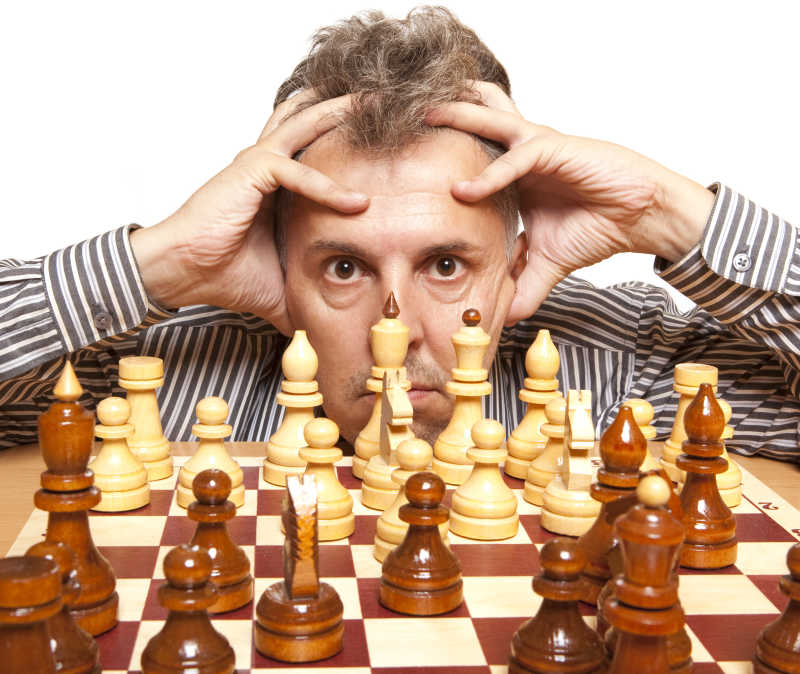 男子双手抱头盯着棋盘上的棋子