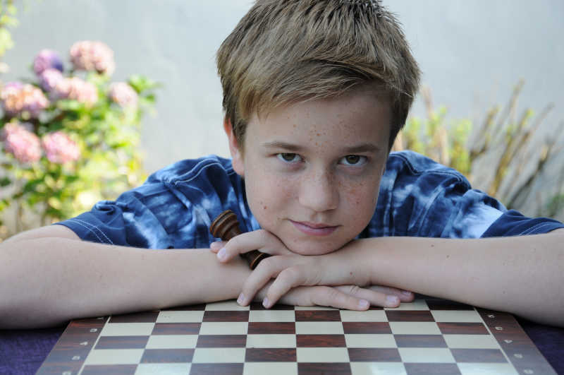 少爷手拿棋子趴在棋盘上