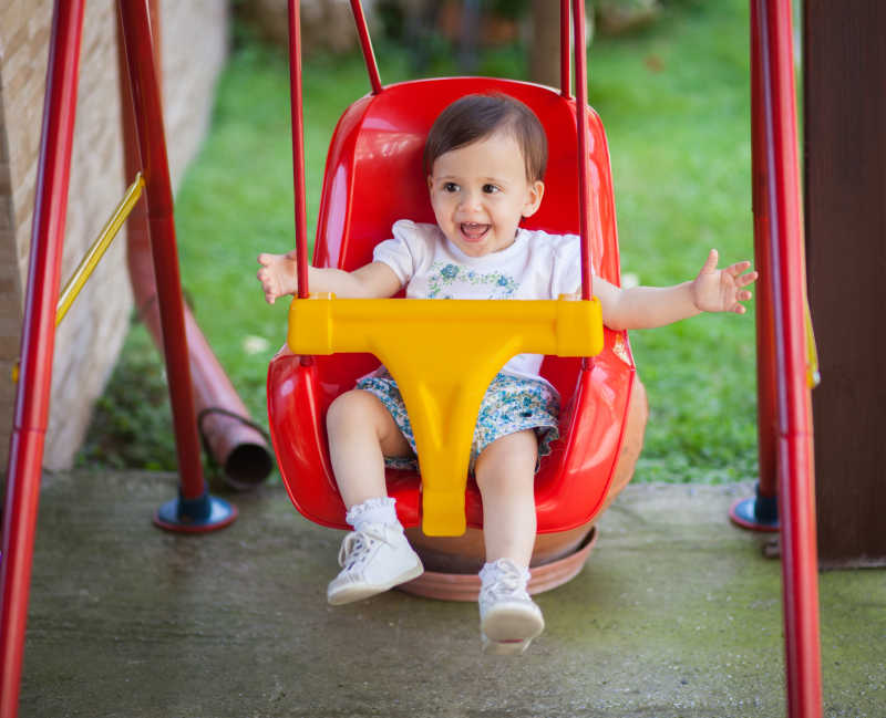 开心的儿童坐在秋千上