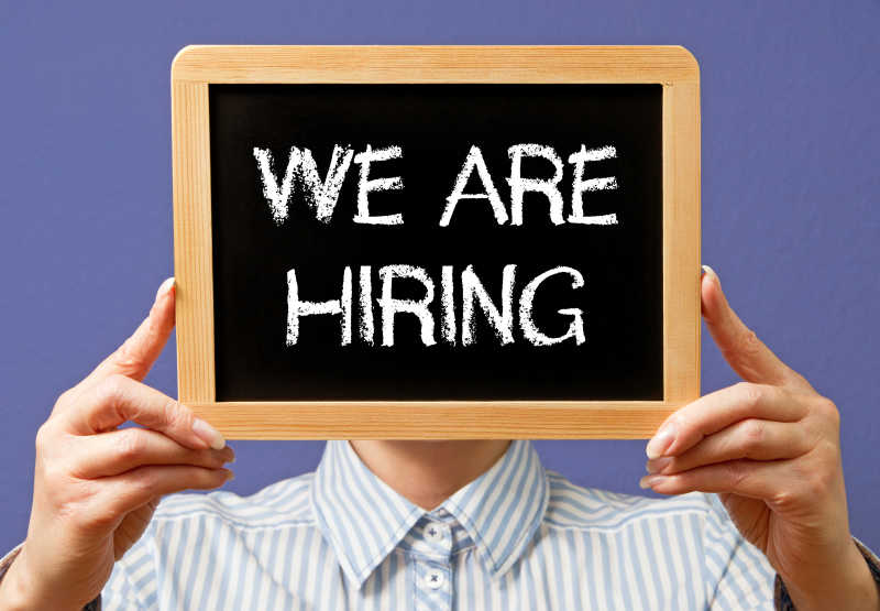 男人举着我们正在招聘黑板
