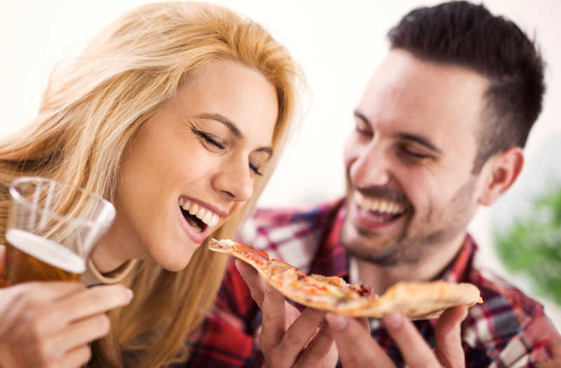 开心的吃披萨的年轻夫妇