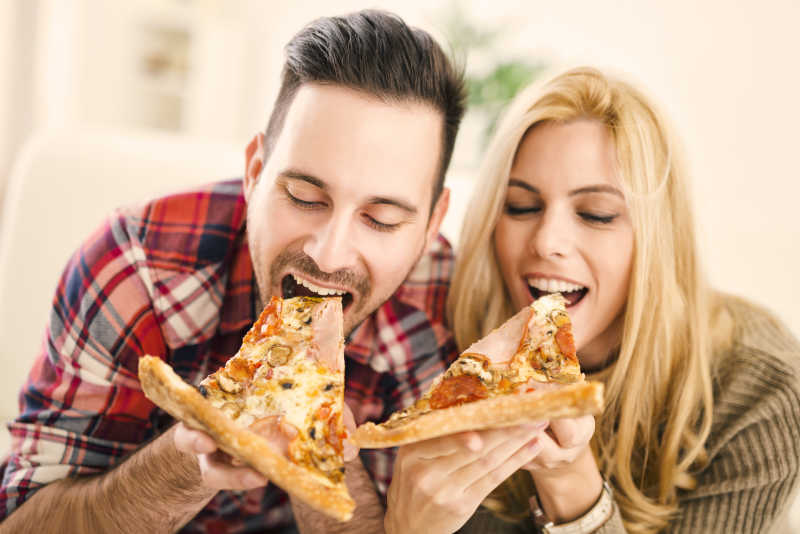 一对吃披萨的年轻夫妻