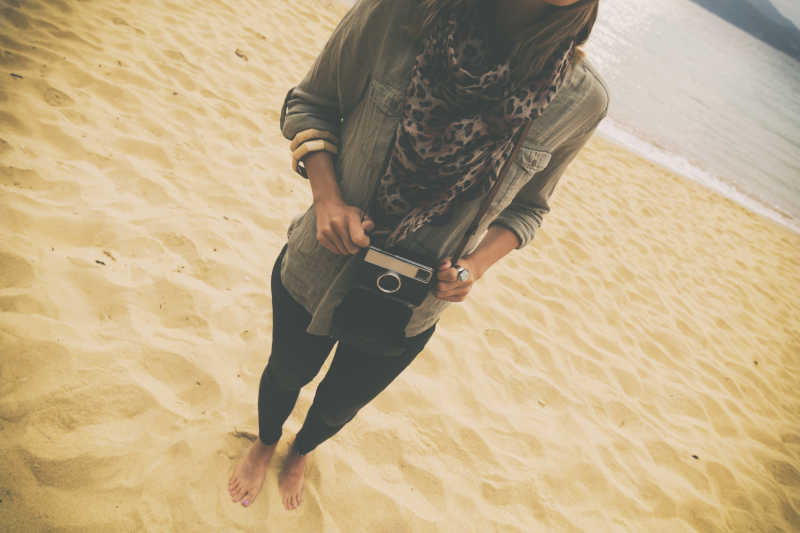 沙滩上戴着相机的美女