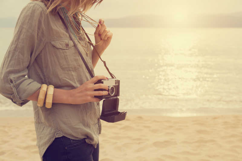 海滩戴着照相机的美女