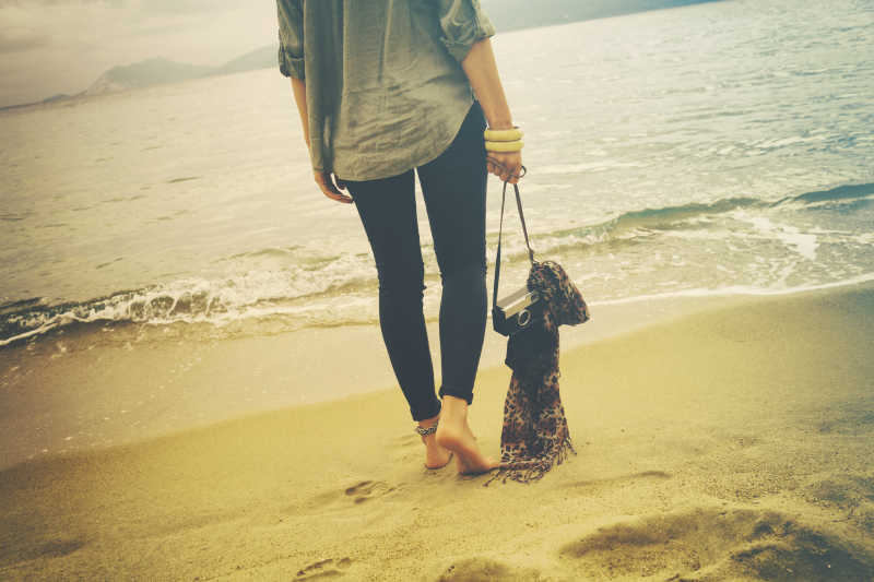 海滩边戴着照相机的美女