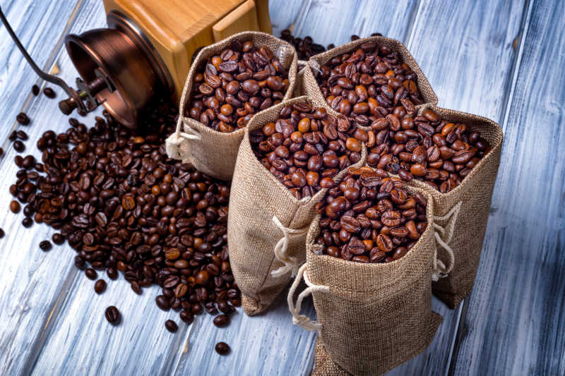 木桌上装满咖啡豆的小麻袋