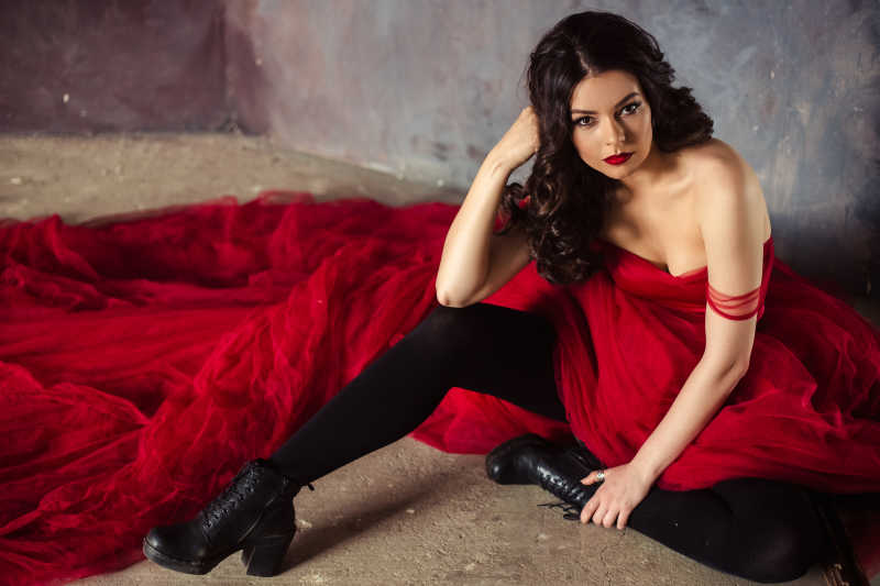 穿着红色长裙坐在地上的性感美女