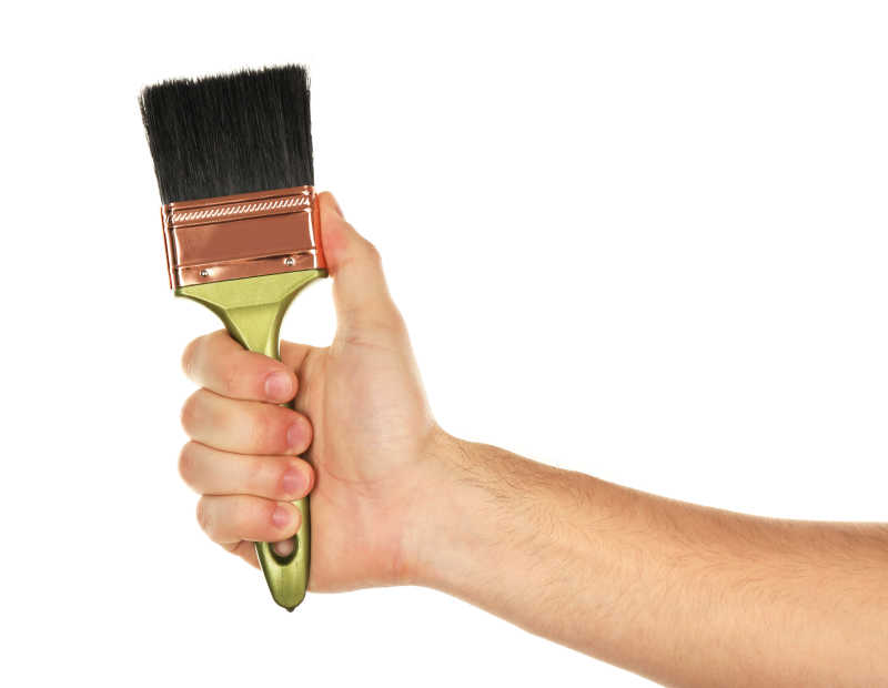 拿着绿色木刷的手