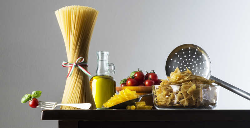 黑色木桌上的丰富的做意大利面的食材