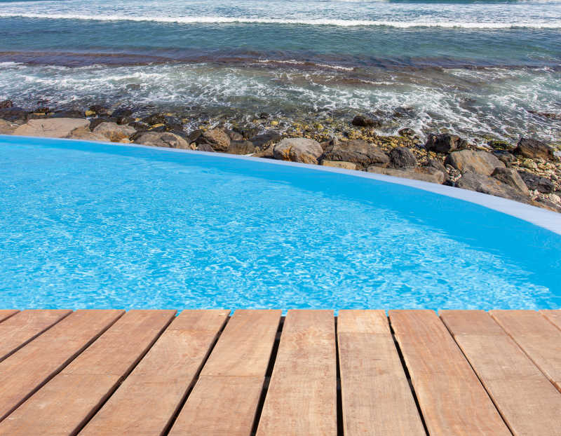 海边游泳池溢出和木制平台