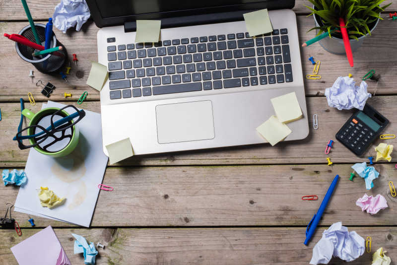 办公桌上凌乱的电脑和纸条