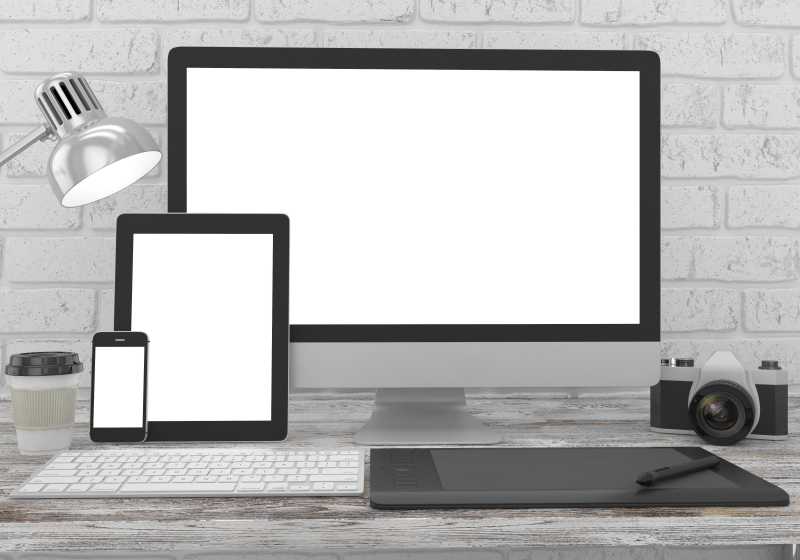 办公桌上的监视器平板电脑和智能手机