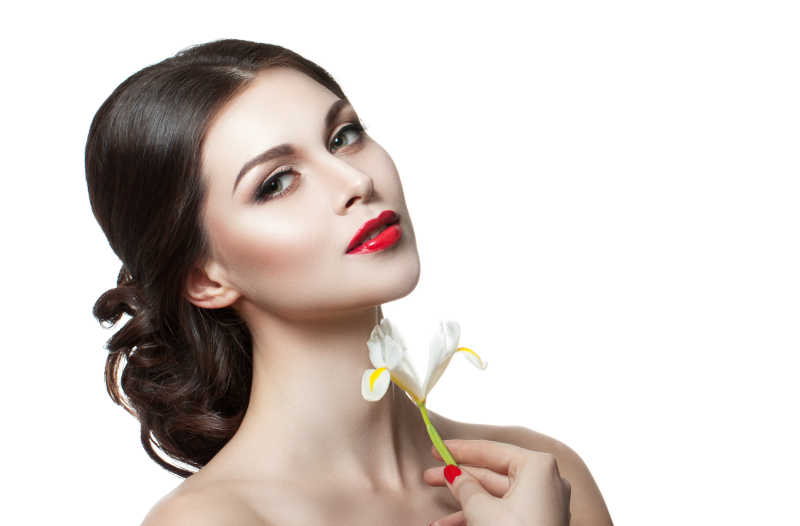 年轻的手中拿花的时尚妆容美丽女人