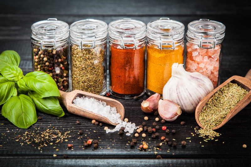 在黑暗的背景下放置不同的药草和香料