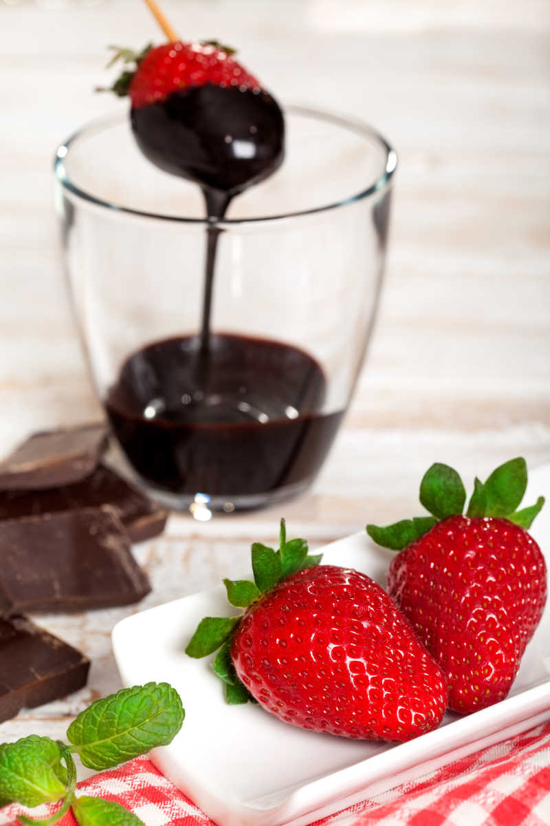 新鲜草莓浸泡在融化的巧克力中
