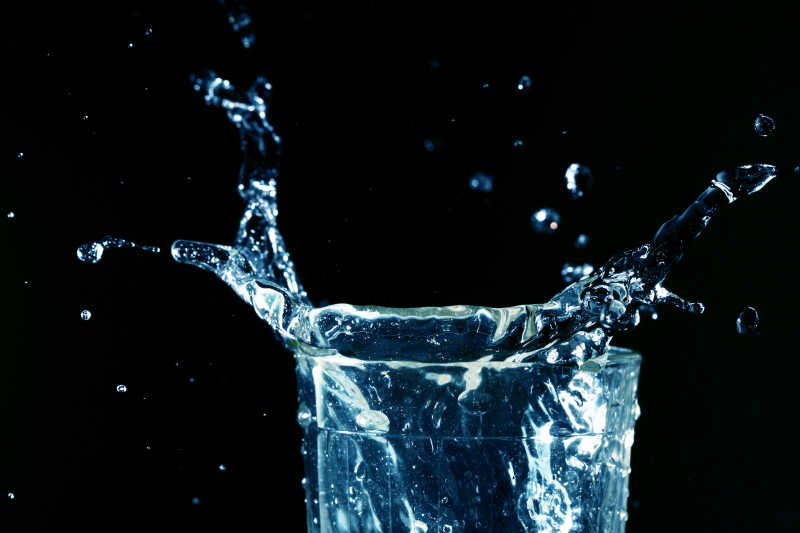 黑色背景下水杯里飞溅的水