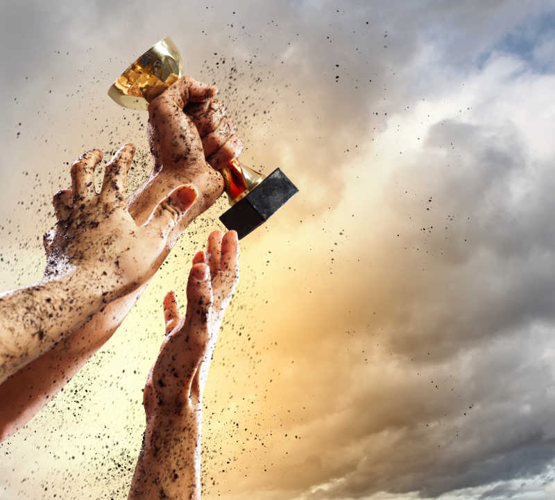 沾满泥土争夺奖杯的三只手