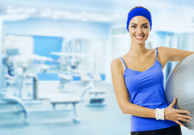 健身房内拿着瑜伽球的女人