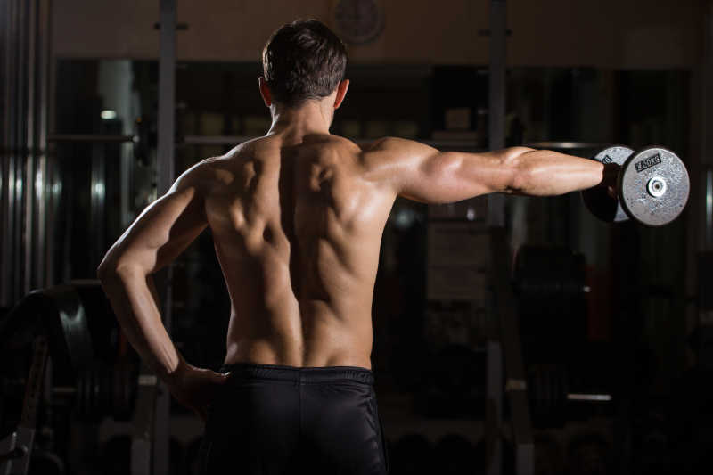 背对着举哑铃的男人