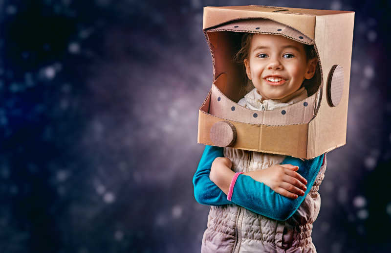 星空背景下穿着玩具宇航服的孩子