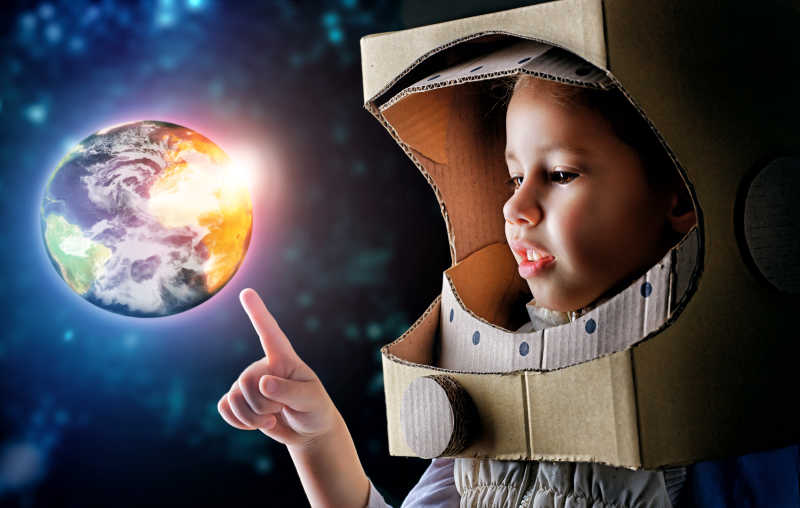 穿着一件太空服的孩子用手指着地球