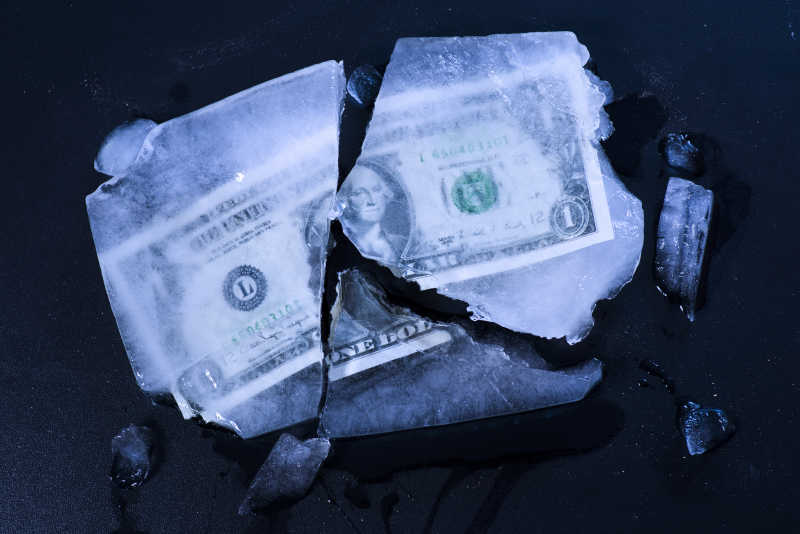 冰冻碎裂的美元钞票