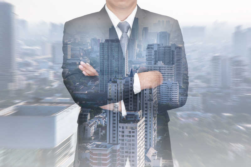 双臂交叉的商人和都市双重曝光