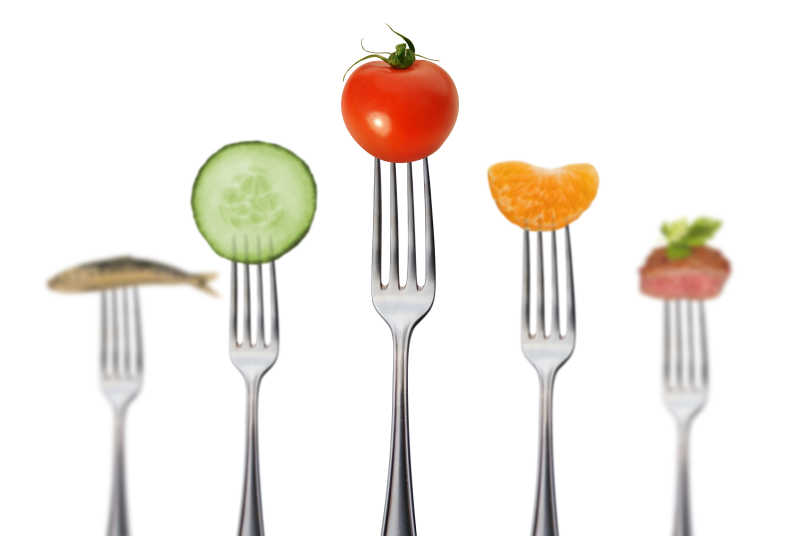 白色背景上有序的刀叉上的健康水果蔬菜