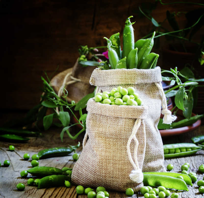 木桌上帆布袋里的新鲜豌豆