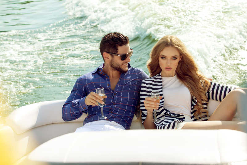 坐在游艇上喝香槟的夫妻