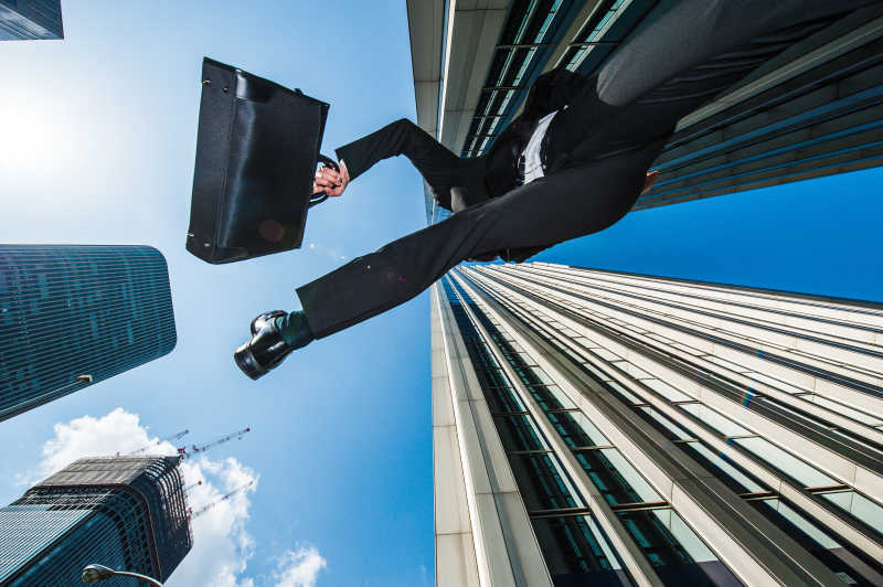 摩天大楼背景下奔跑的商人