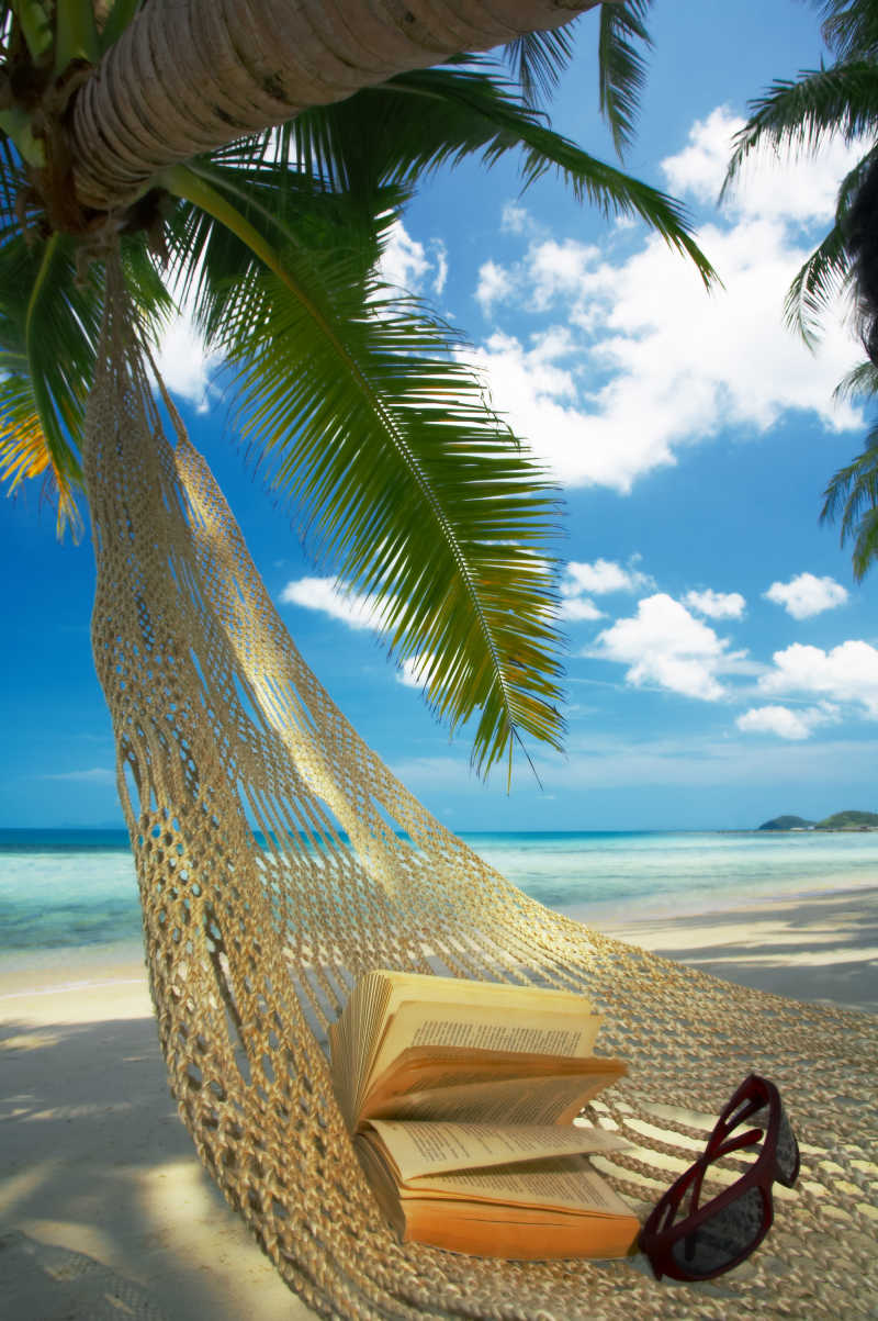 蓝天白云下棕榈树下的吊床