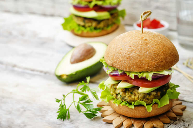 放在木桌上的精致的牛油果汉堡