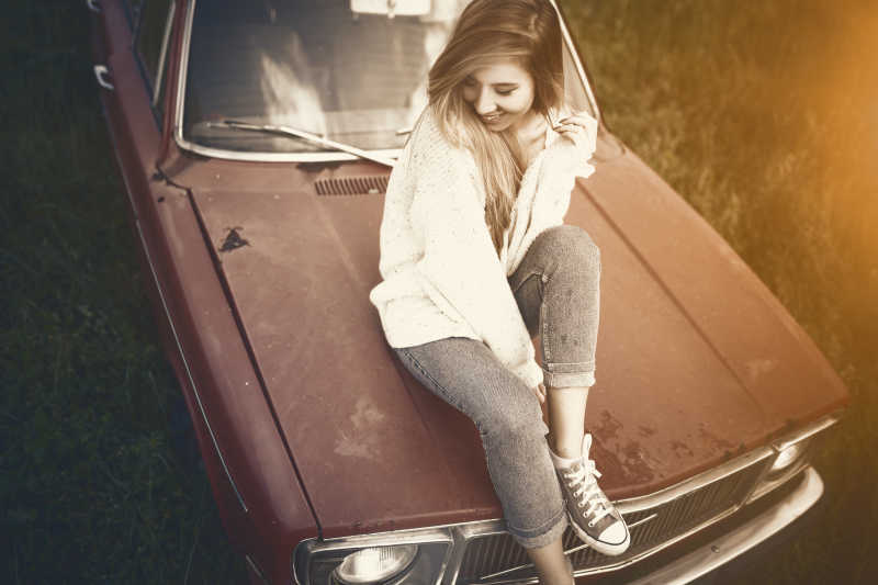 复古滤镜下的车上的时尚女人