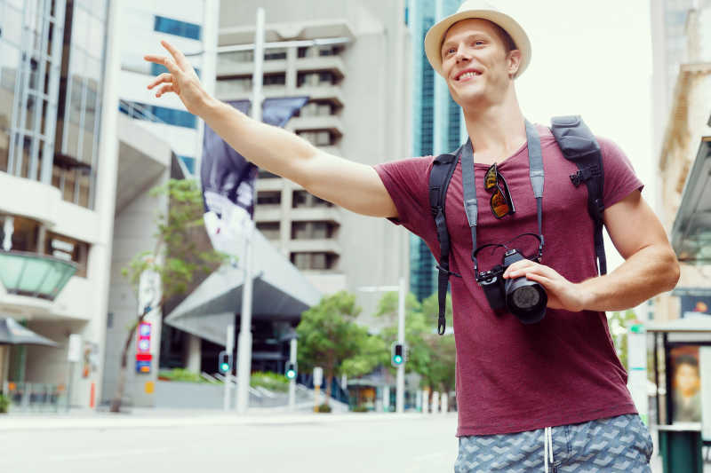 年轻男游客在街上招呼出租车