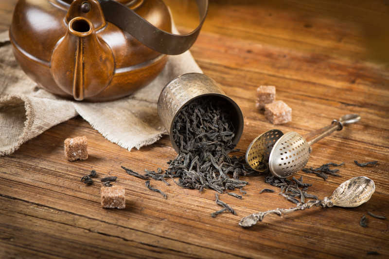 木桌上倒出来的茶叶和茶具
