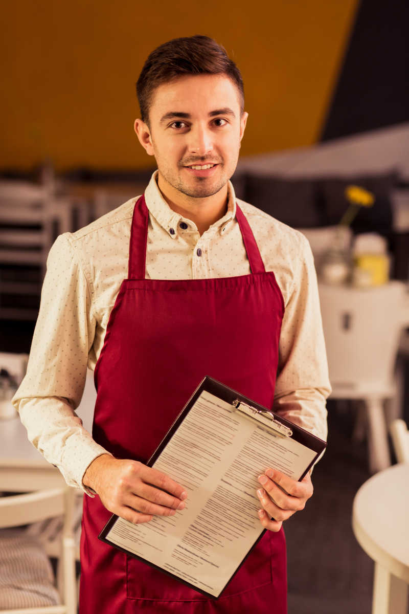 拿着餐厅菜单的年轻侍者
