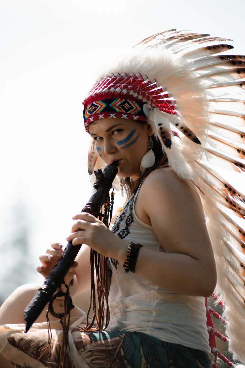 在一棵树上演奏长笛的印第安美女
