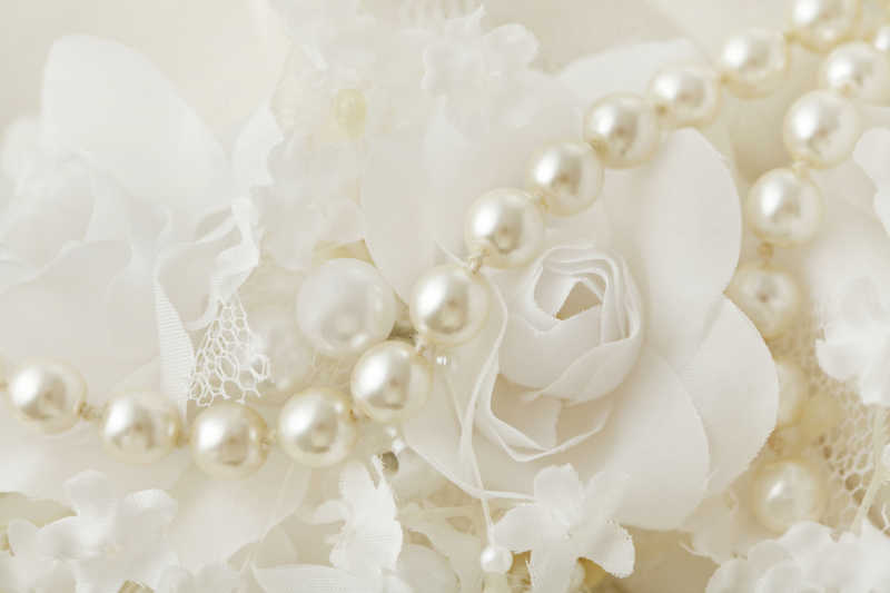 白色花朵背景下的婚纱珍珠项链