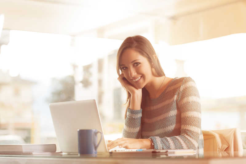 用笔记本电脑工作的漂亮女孩