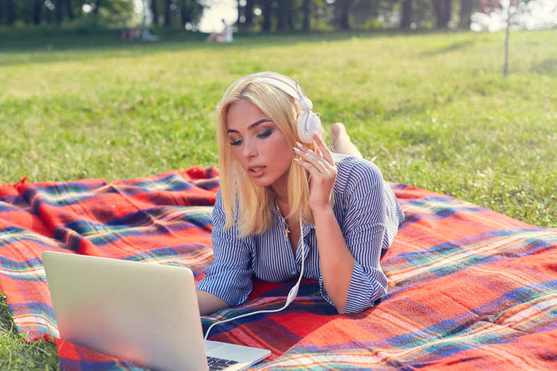 躺在草地上听音乐的女孩