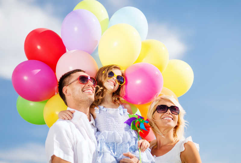 带着彩色气球的快乐家庭